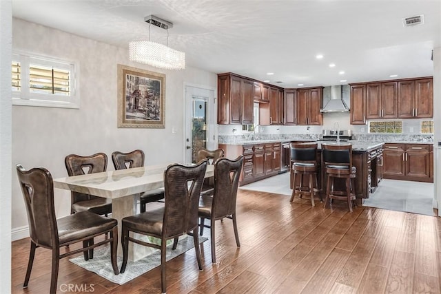 dining space with light wood-style flooring, visible vents, and recessed lighting