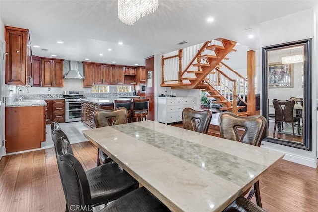 dining room featuring recessed lighting, visible vents, a chandelier, light wood-type flooring, and stairs