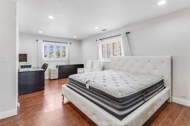 bedroom featuring multiple windows, baseboards, wood finished floors, and recessed lighting