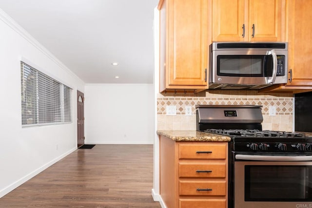 kitchen featuring backsplash, baseboards, stainless steel appliances, and crown molding