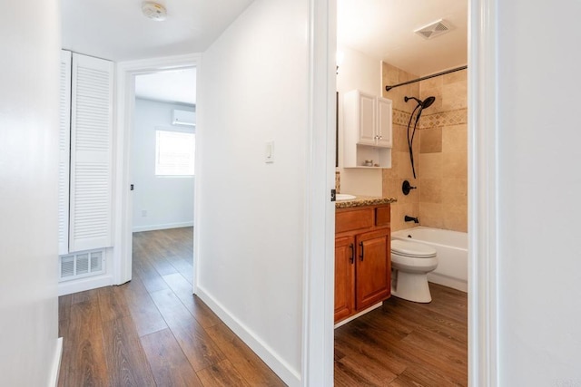 full bathroom with vanity, wood finished floors, visible vents, and baseboards