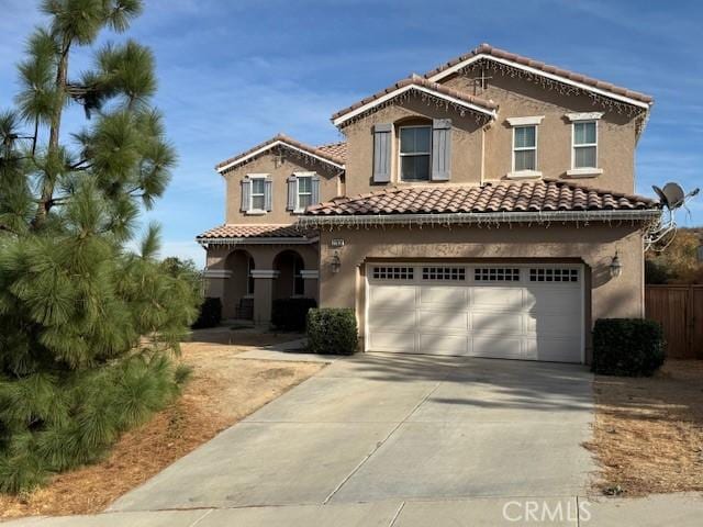 view of front of home featuring a tile roof, driveway, an attached garage, and stucco siding