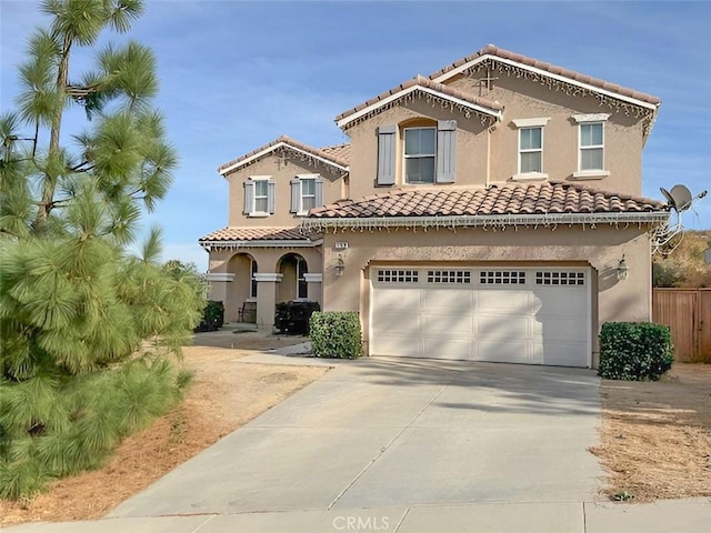 mediterranean / spanish-style house featuring stucco siding, concrete driveway, an attached garage, and a tile roof