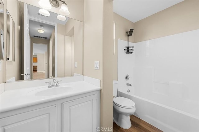 full bath featuring toilet, wood finished floors, vanity, visible vents, and tub / shower combination