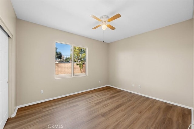 unfurnished bedroom with a ceiling fan, a closet, baseboards, and wood finished floors