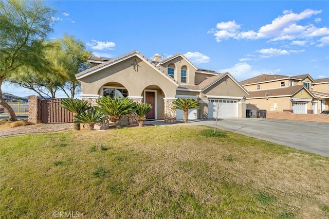 view of front facade with driveway, an attached garage, a front yard, and stucco siding