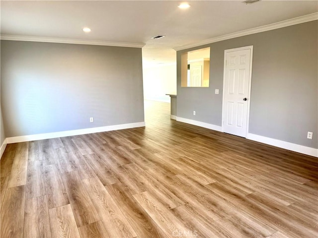 spare room with recessed lighting, wood finished floors, visible vents, baseboards, and ornamental molding