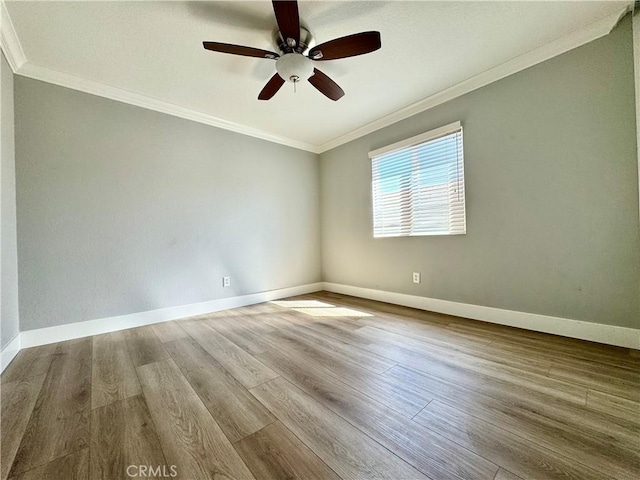 empty room with a ceiling fan, baseboards, ornamental molding, and wood finished floors