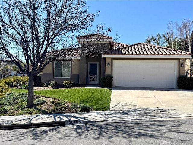 mediterranean / spanish home featuring a garage, concrete driveway, a tile roof, a front lawn, and stucco siding