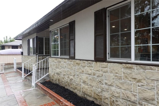 view of side of home with stone siding and stucco siding