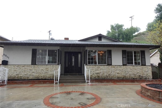 view of front of home featuring stone siding and stucco siding