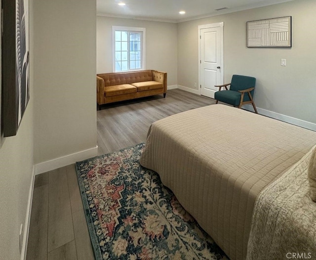 bedroom with recessed lighting, crown molding, baseboards, and wood finished floors