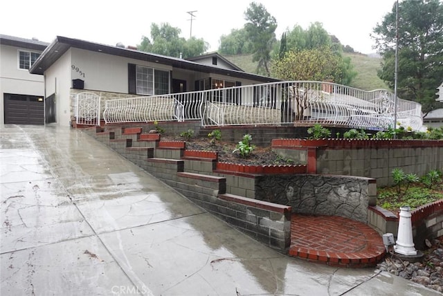 view of front facade with concrete driveway and stucco siding