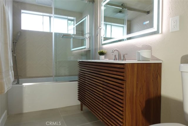 bathroom with tile patterned flooring, toilet, shower / bath combination with glass door, vanity, and backsplash