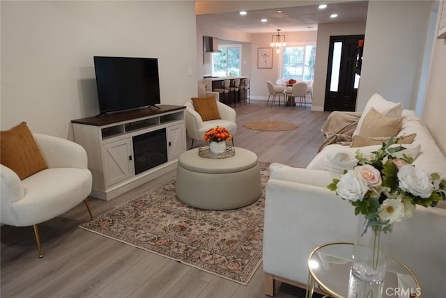 living area with light wood-style floors, baseboards, and recessed lighting