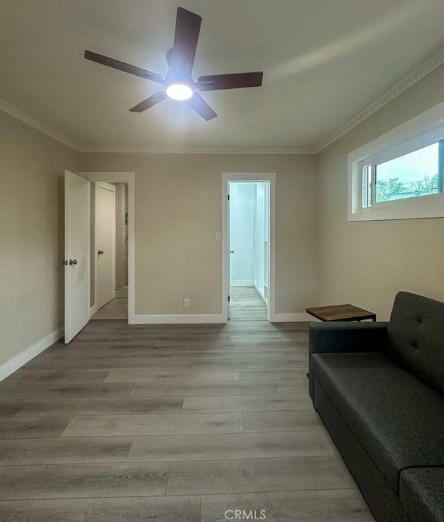 interior space featuring baseboards, crown molding, and light wood finished floors