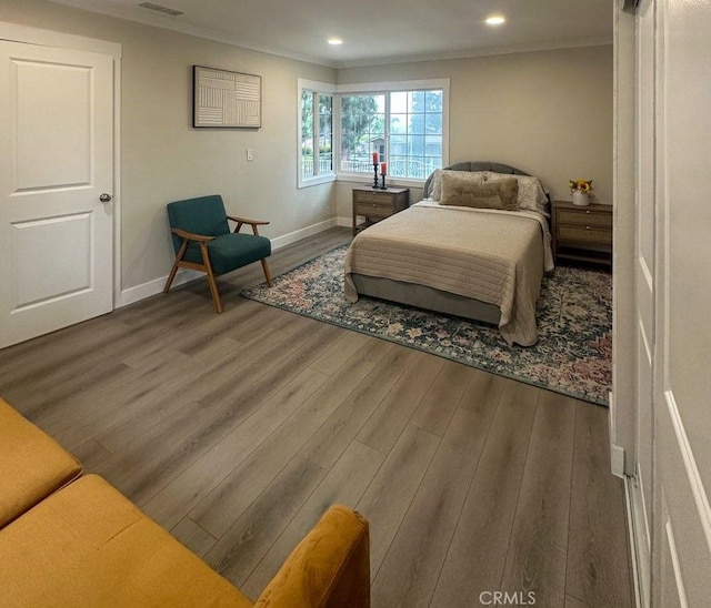 bedroom with baseboards, ornamental molding, wood finished floors, and recessed lighting