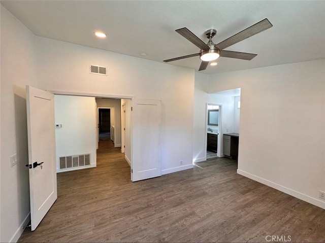 spare room featuring wood finished floors, visible vents, and baseboards