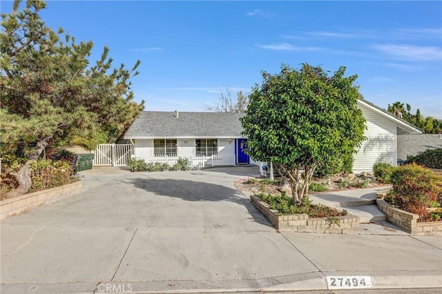 obstructed view of property with driveway and a gate