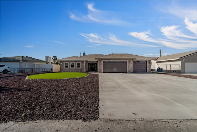 view of front of home featuring fence, driveway, and an attached garage