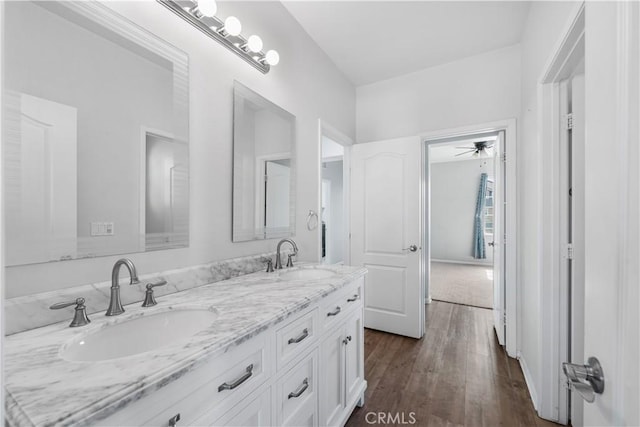 full bath featuring double vanity, a sink, and wood finished floors