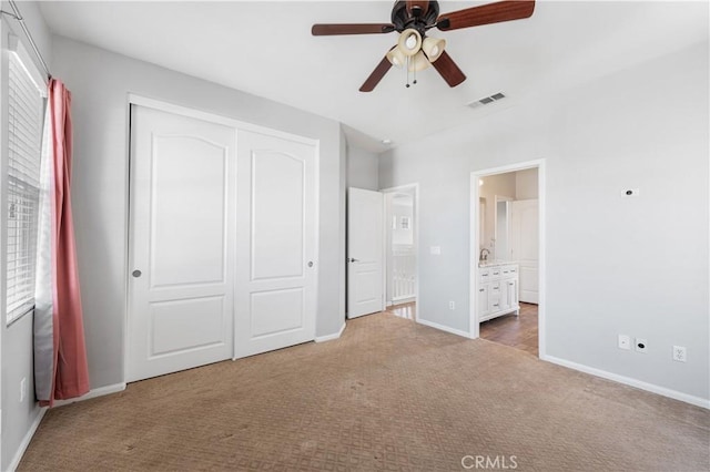 unfurnished bedroom featuring carpet floors, multiple windows, baseboards, and a closet