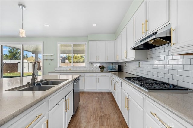 kitchen with appliances with stainless steel finishes, a sink, white cabinetry, and under cabinet range hood