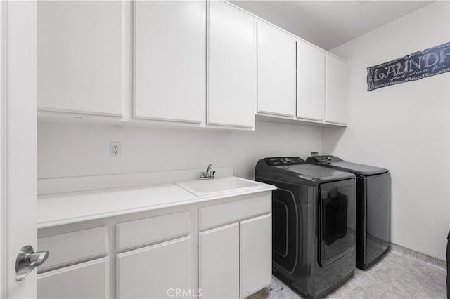 laundry room with cabinet space, separate washer and dryer, and a sink