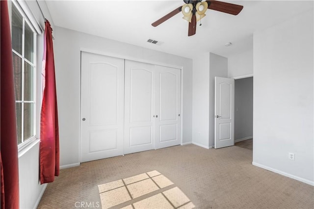 unfurnished bedroom with carpet floors, a closet, visible vents, a ceiling fan, and baseboards