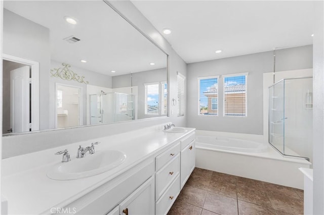 full bathroom with a stall shower, double vanity, a sink, and a bath