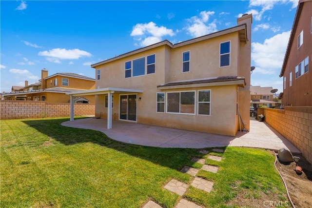 back of house with a patio area, a fenced backyard, a yard, and stucco siding