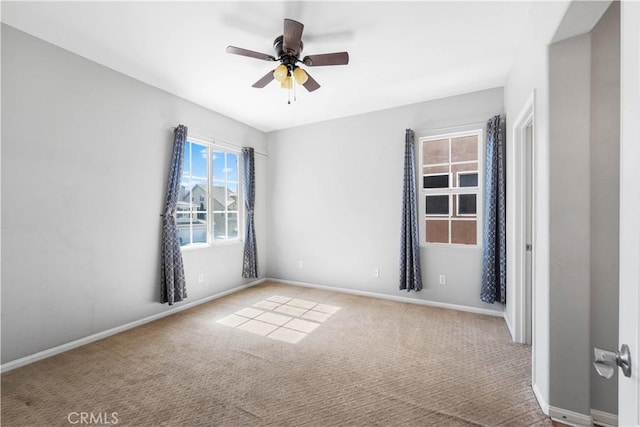 spare room with carpet flooring, ceiling fan, and baseboards