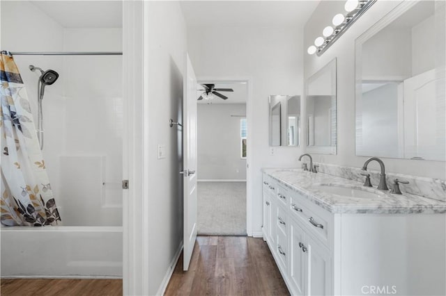 full bath with shower / bath combo, a sink, and wood finished floors