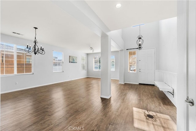 entrance foyer with a chandelier, baseboards, visible vents, and dark wood-type flooring