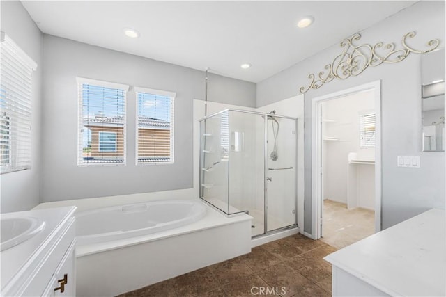 full bathroom with a stall shower, plenty of natural light, and vanity