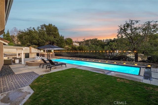 view of swimming pool with a patio area, a fenced in pool, fence, and a lawn