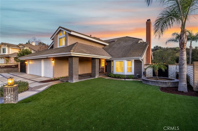 view of front of property with a garage, fence, a yard, concrete driveway, and a chimney