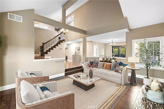living room featuring stairs, wood finished floors, visible vents, and an inviting chandelier