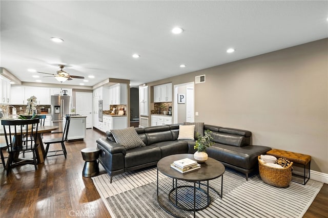 living room featuring baseboards, visible vents, a ceiling fan, dark wood-style flooring, and recessed lighting