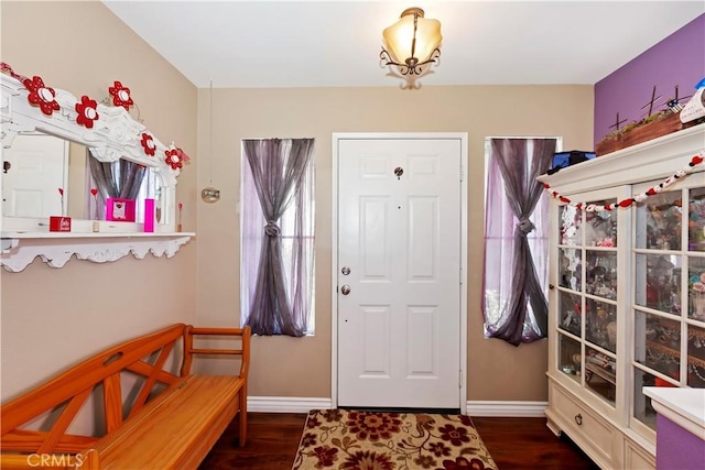 foyer entrance with dark wood finished floors and baseboards