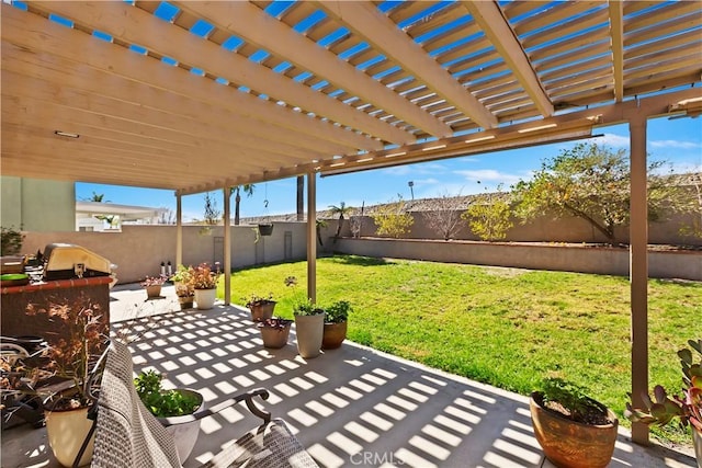 view of patio with a fenced backyard, a pergola, and exterior kitchen