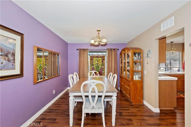 dining area with baseboards, visible vents, dark wood-type flooring, and a notable chandelier