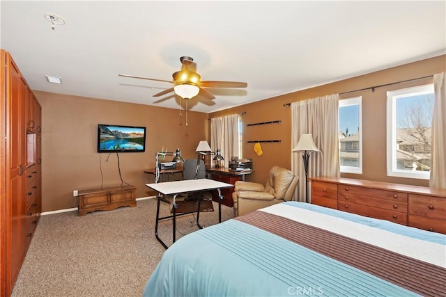 bedroom with light colored carpet, ceiling fan, and baseboards