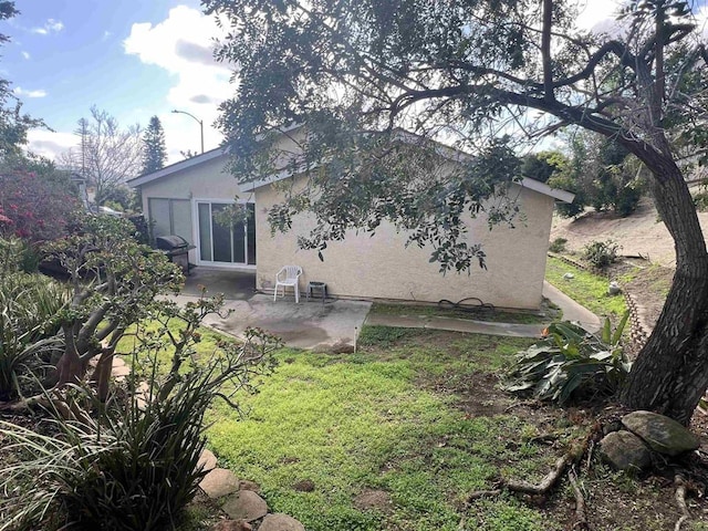 back of house with a patio area and stucco siding