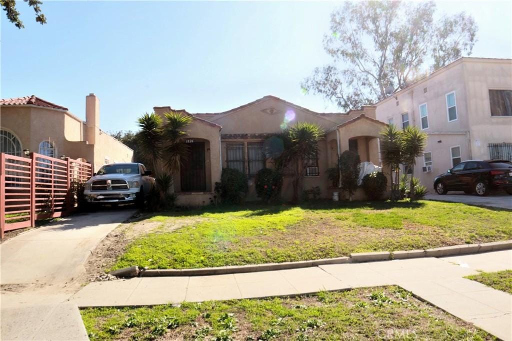 mediterranean / spanish-style home featuring a front lawn and stucco siding