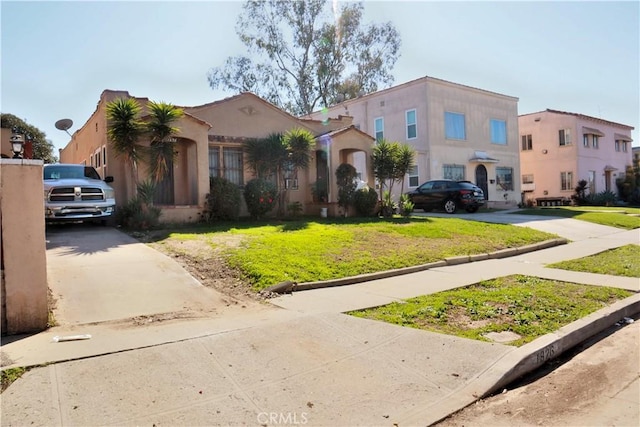 townhome / multi-family property featuring a front lawn and stucco siding