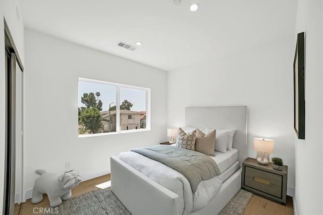 bedroom with light wood-style floors, recessed lighting, visible vents, and baseboards