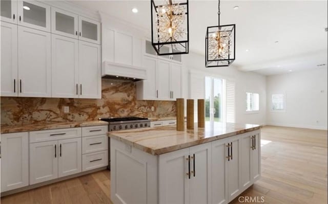 kitchen with extractor fan, light wood-type flooring, backsplash, and white cabinetry