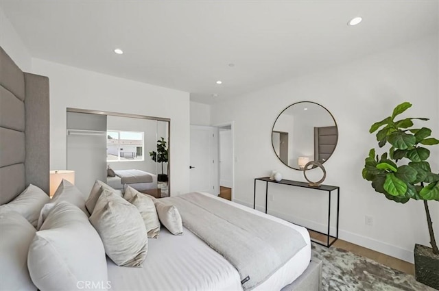 bedroom with recessed lighting, a closet, baseboards, and wood finished floors