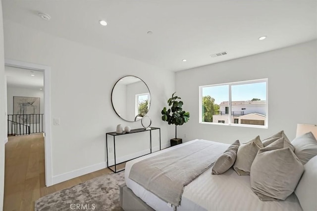 bedroom featuring recessed lighting, visible vents, baseboards, and wood finished floors